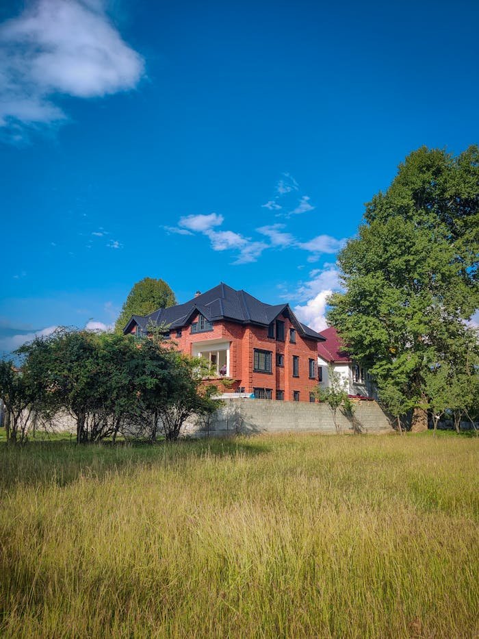 Crafting Captivating Headlines: Your awesome post title goes here Red brick house behind trees under clear blue sky, surrounded by nature